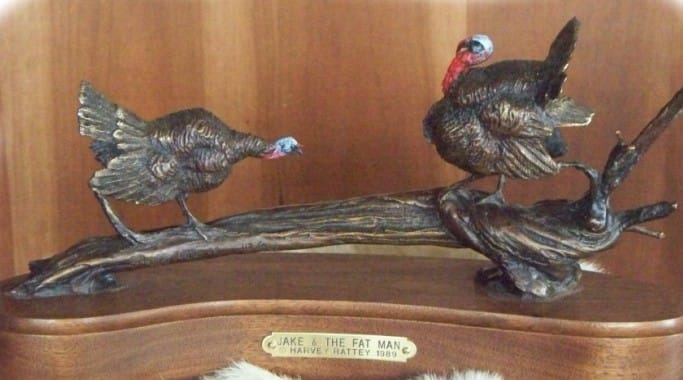 Bronze sculpture of two wild turkeys in a standoff.