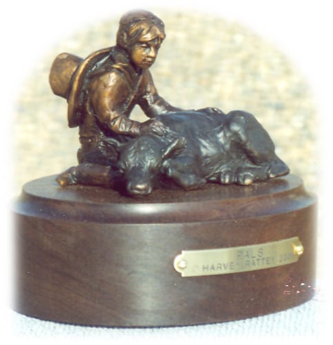 Bronze sculpture of young cowboy and a sleeping calf.