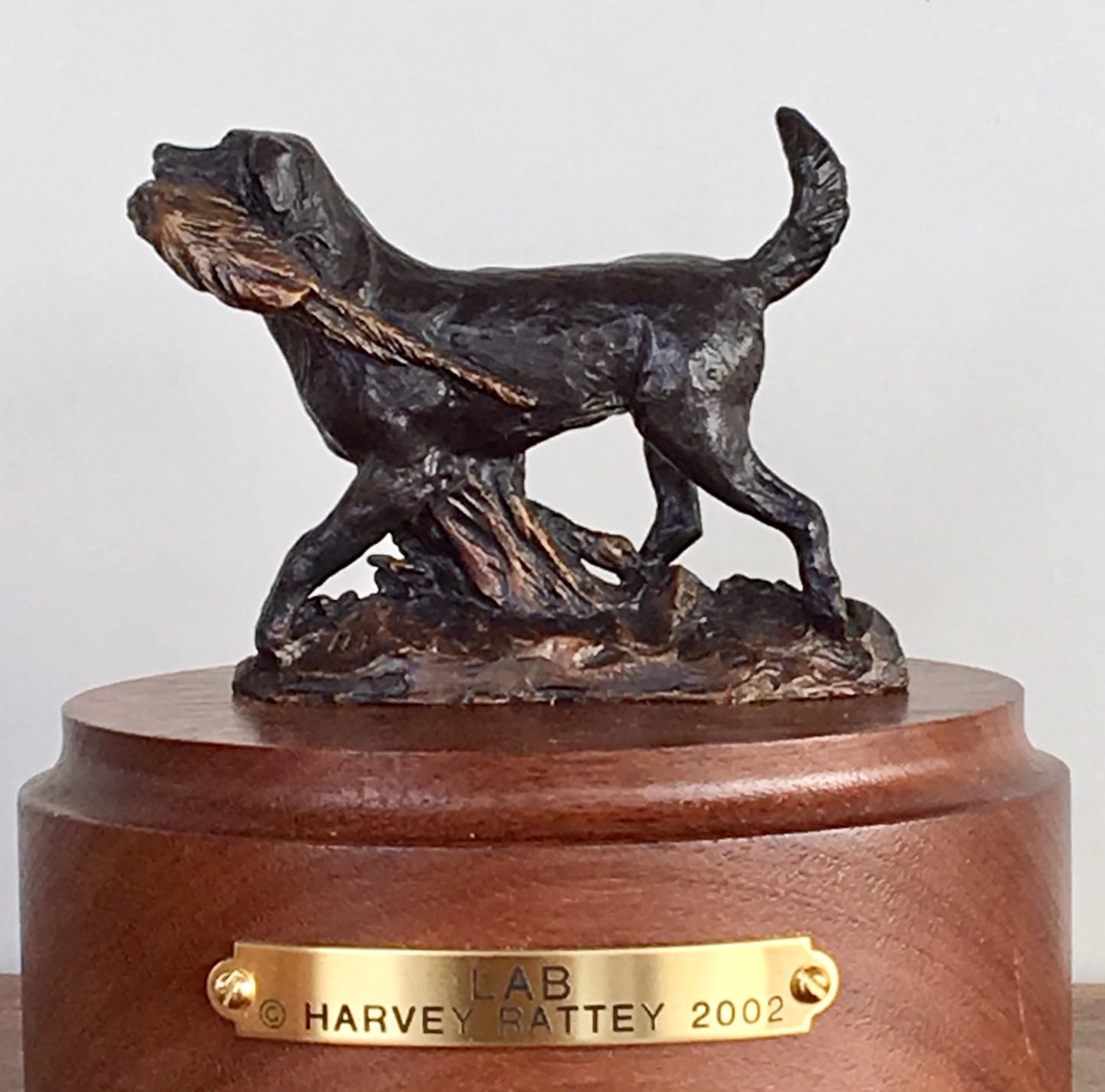 Bronze sculpture of a Labrador Retriever returning to his master with game in his mouth.