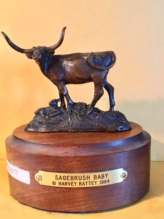 Small bronze sculpture of a longhorn cow and her newborn calf.