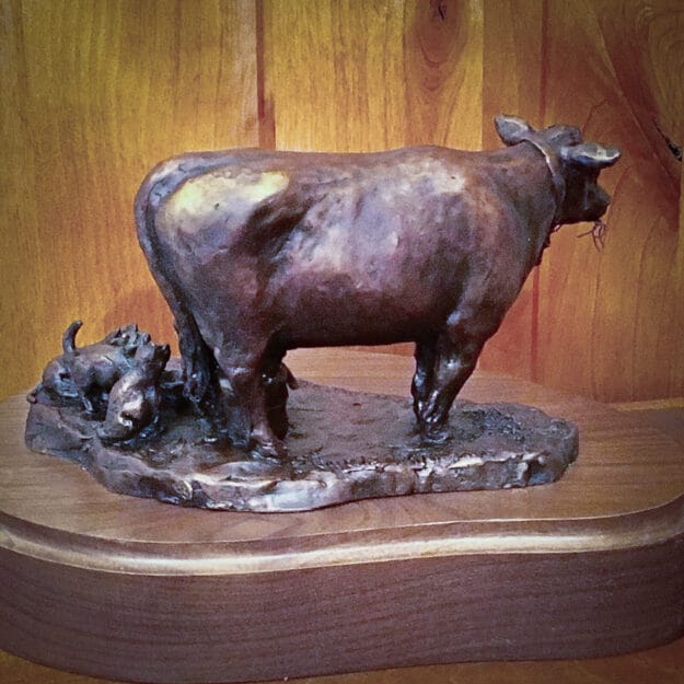 bronze sculpture of milk cow, little girl and cats