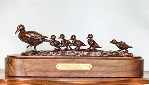 Charming bronze sculpture of a mother duck followed by her ducklings.