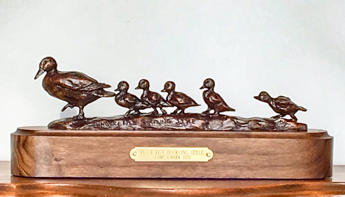 Charming bronze sculpture of a mother duck followed by her ducklings.